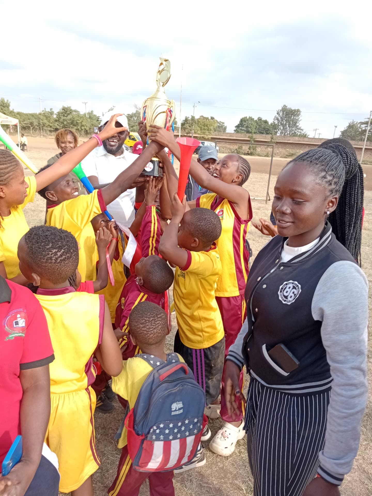 Myfin School football team lifting a winners trophy together on the pitch