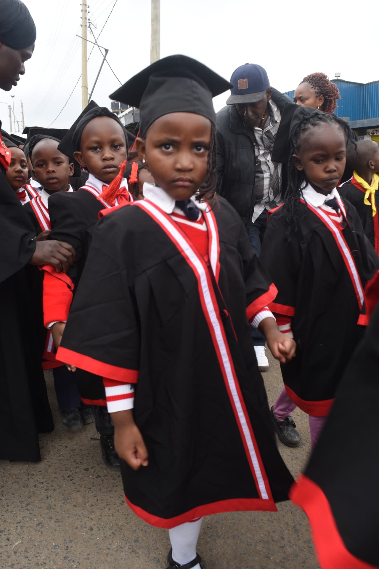Myfin School early years learners in graduation gowns and caps during a parade