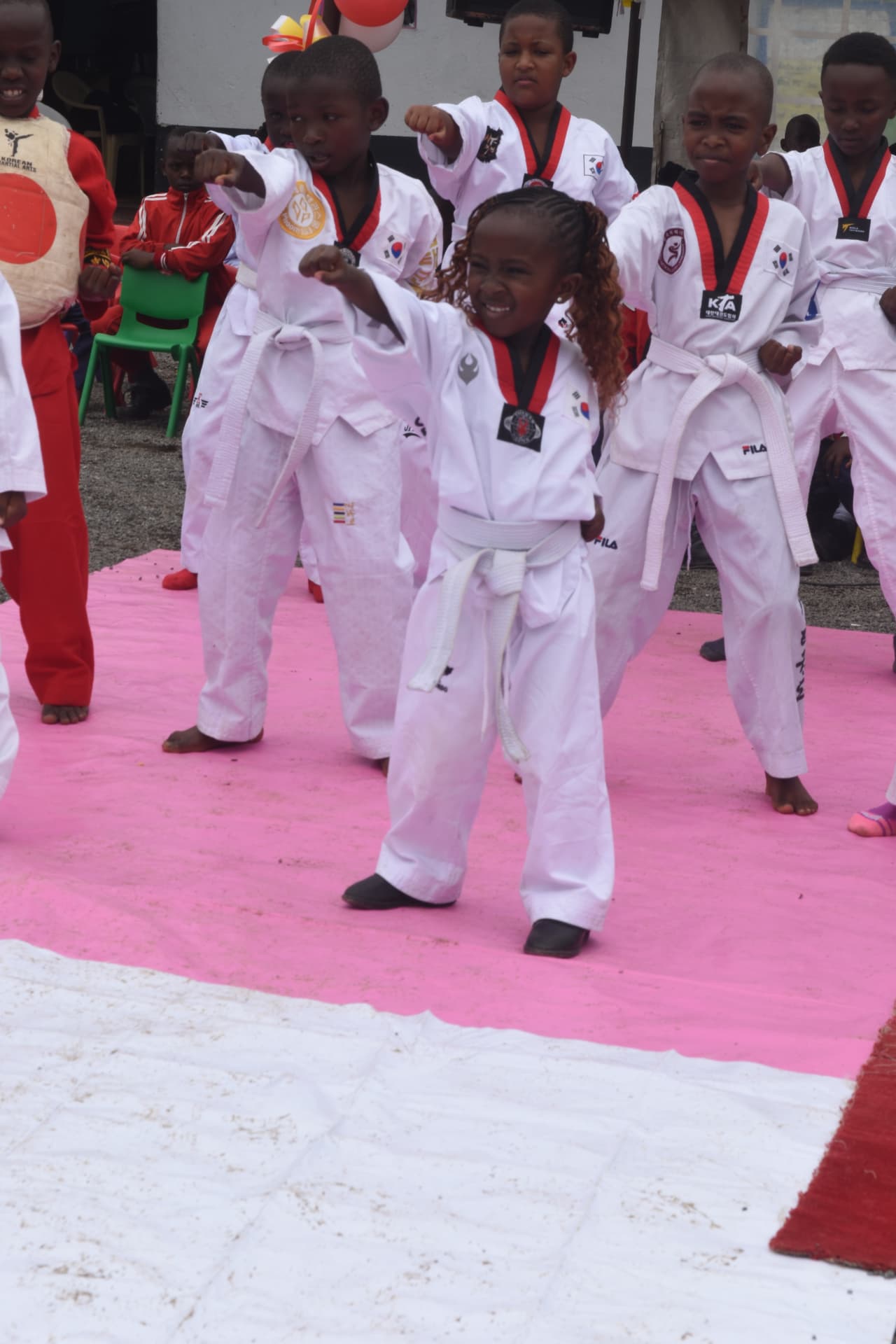 Young Myfin School learners in taekwondo dobok performing a punching drill