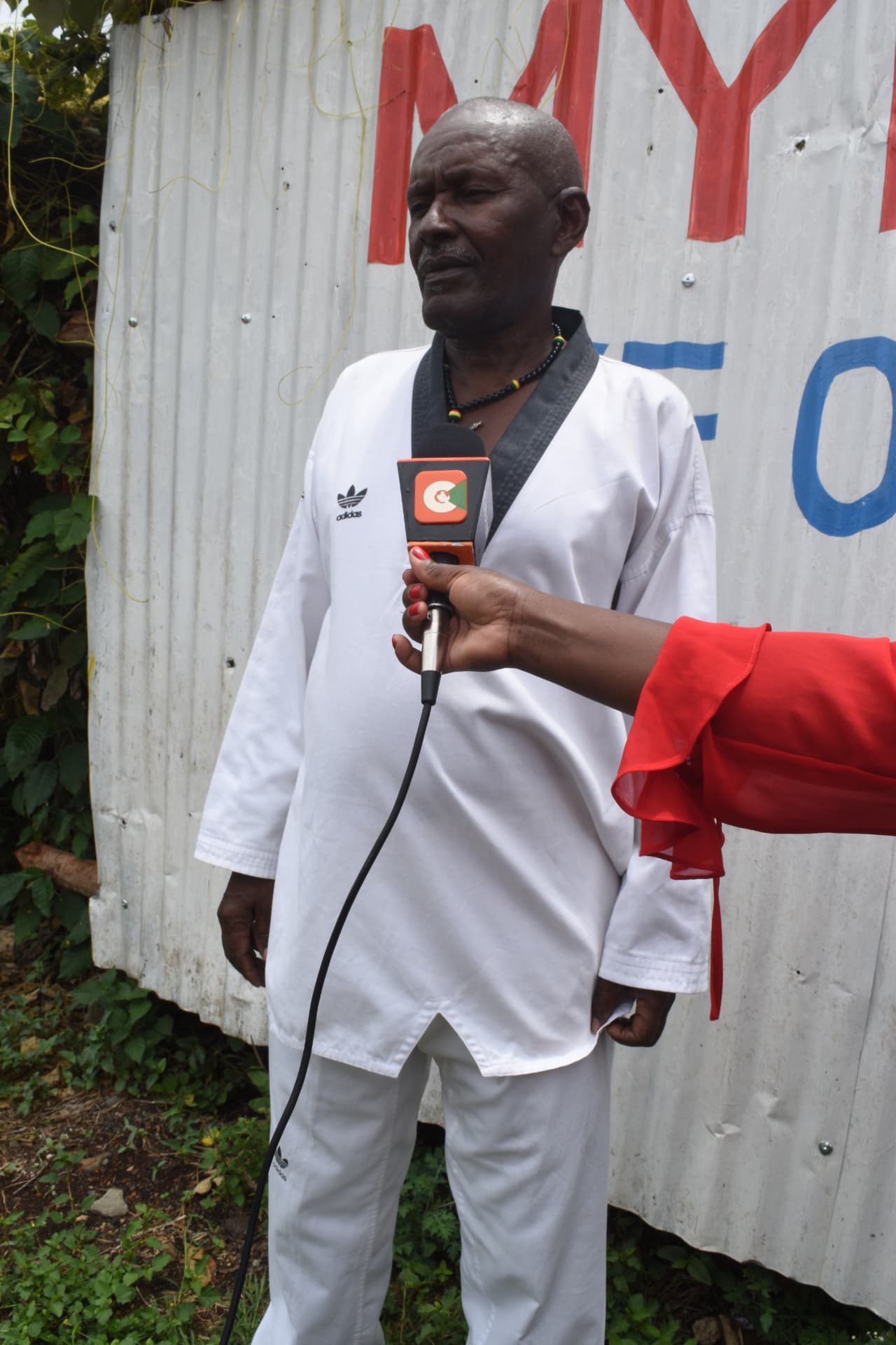 Myfin School taekwondo coach being interviewed by a television reporter