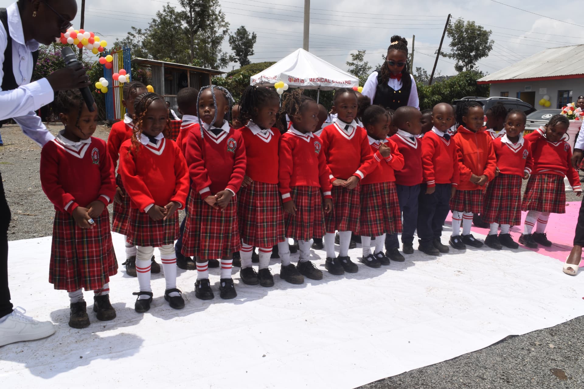 Myfin School learners in red uniform learning together outdoors