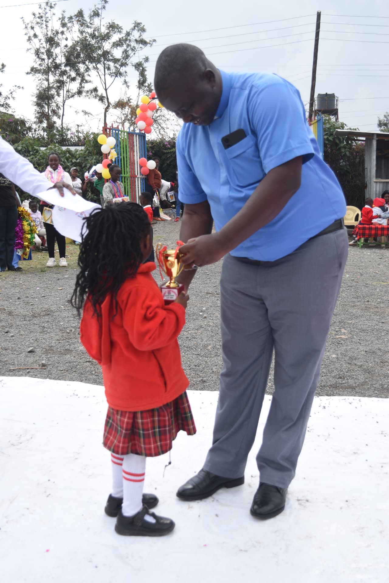 Young Myfin School learner receiving a trophy and certificate at prize giving