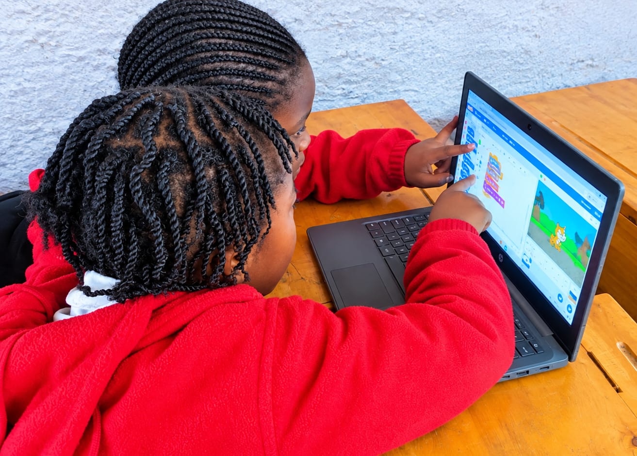 Myfin School learners coding together on a laptop during an AI and robotics lesson