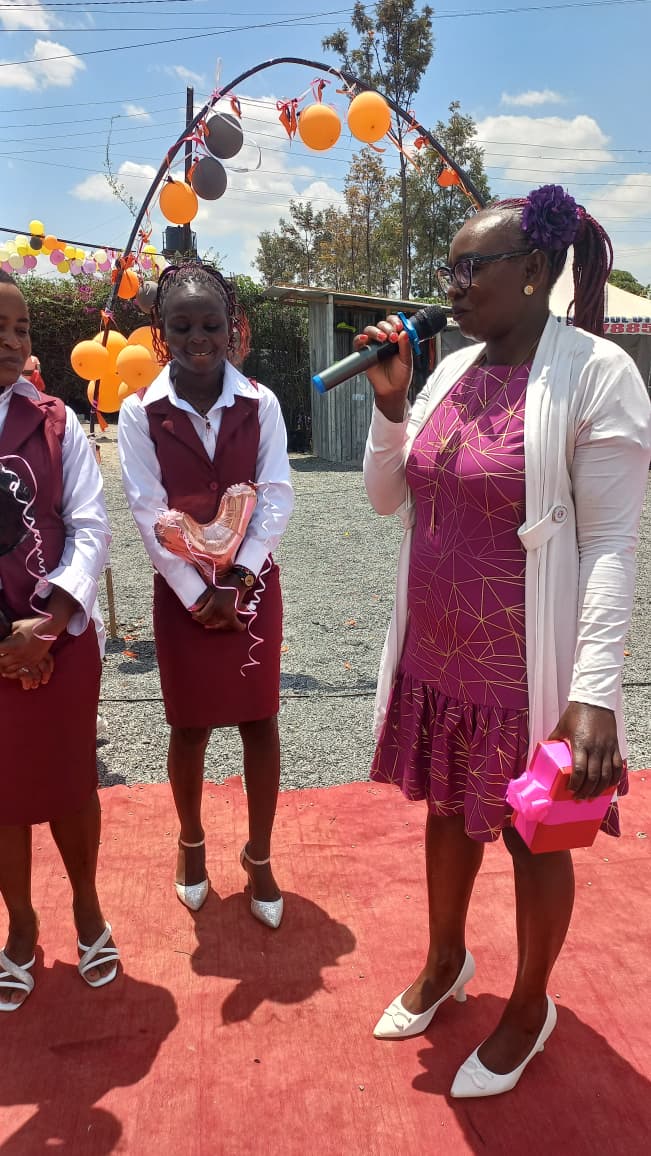 Myfin School teacher addressing learners with a microphone at a school celebration