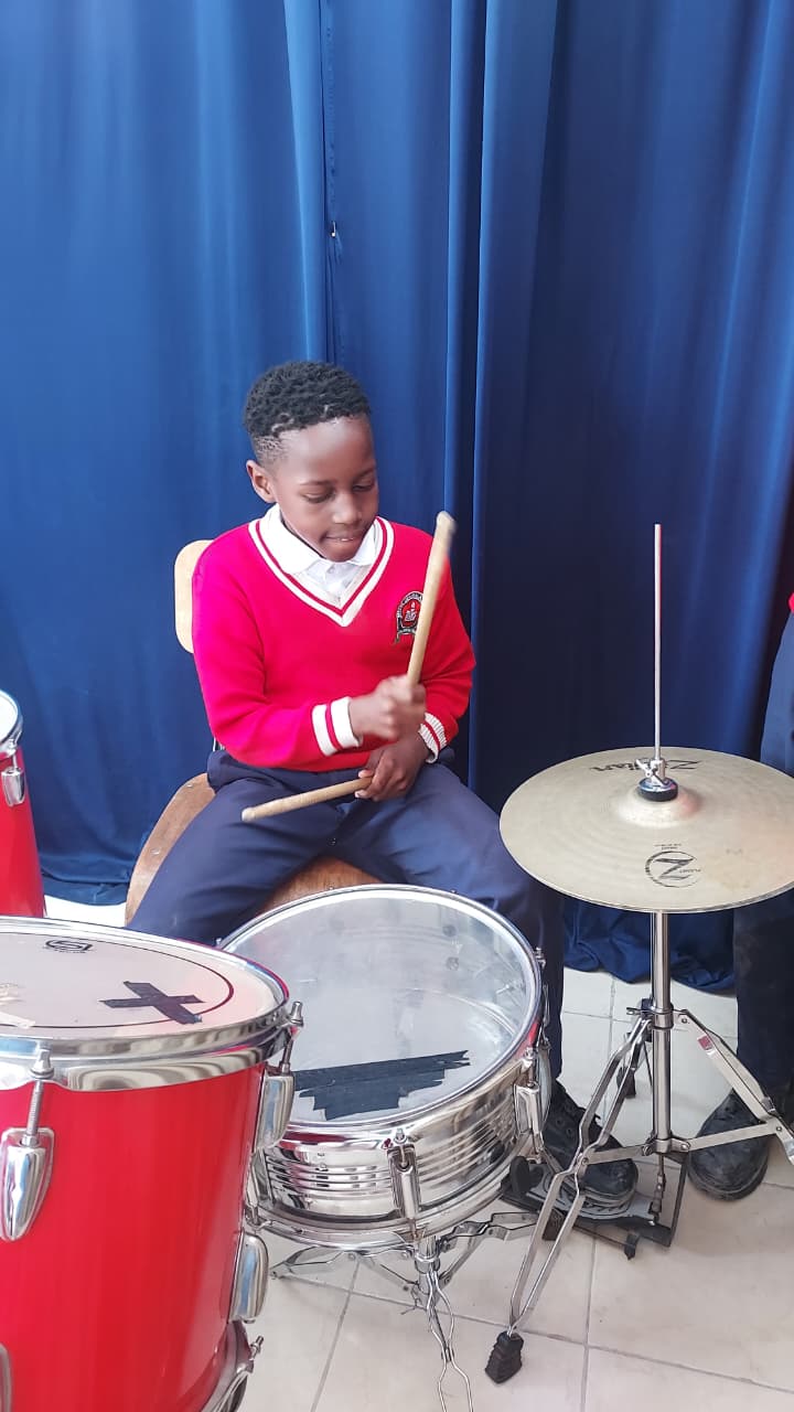 Myfin School learner playing the drum kit during a music lesson