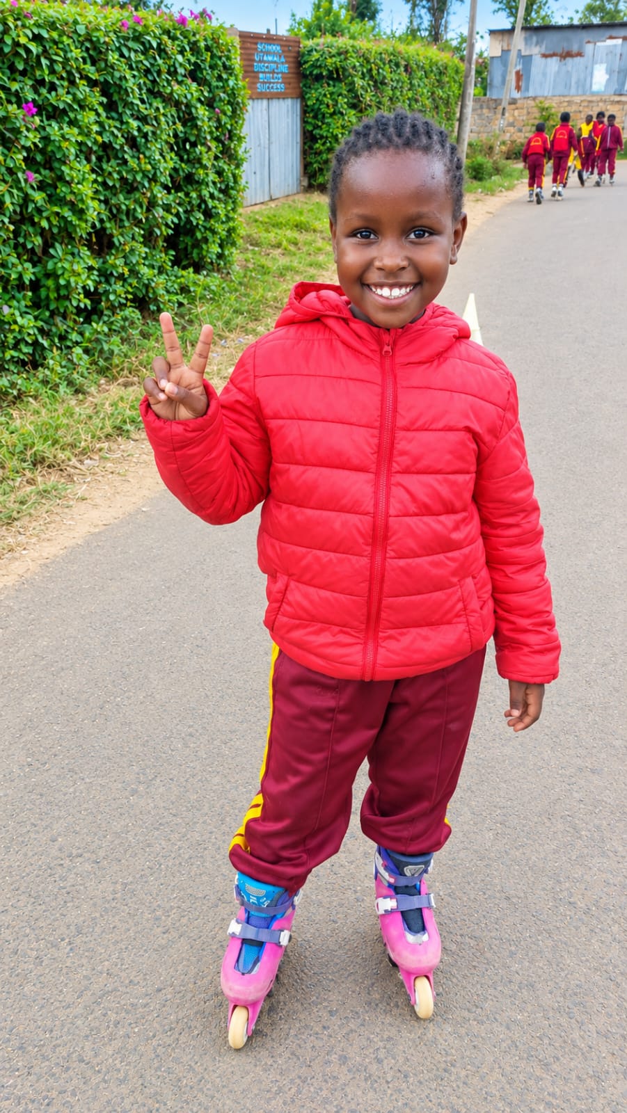Smiling Myfin School skater in a red jacket giving a peace sign after skating practice