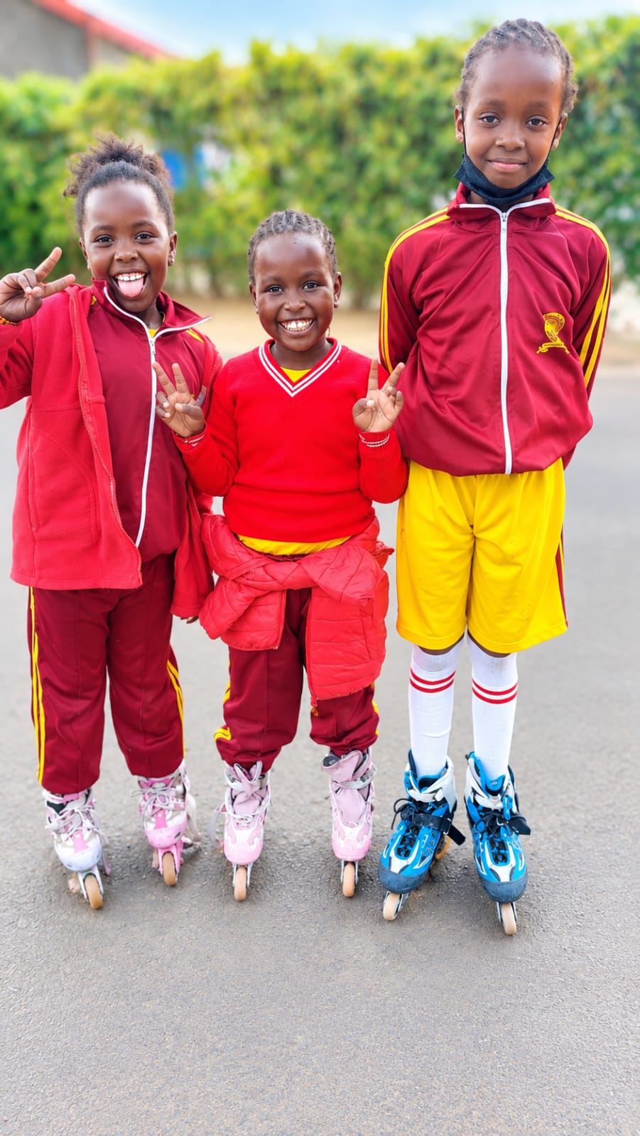 Three young Myfin School skaters in tracksuits posing in their inline skates